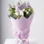 باقة يد من ماتشيولا بنفسجية، ورود سبراي بيضاء، وأزهار خضراء