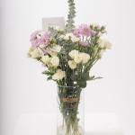 مزهرية شفافة مع ورود سبراي بيضاء وأزهار بنفسجية